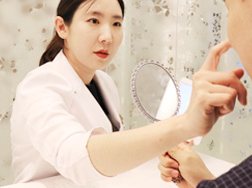 손거울을 들고 시술 계획을 설명하는 대표원장